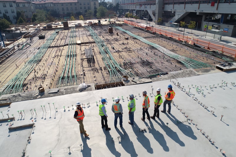 Construction workers wearing hard hats and safety vests on an active job site