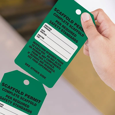 Tearing a green safety tag off at the perforation